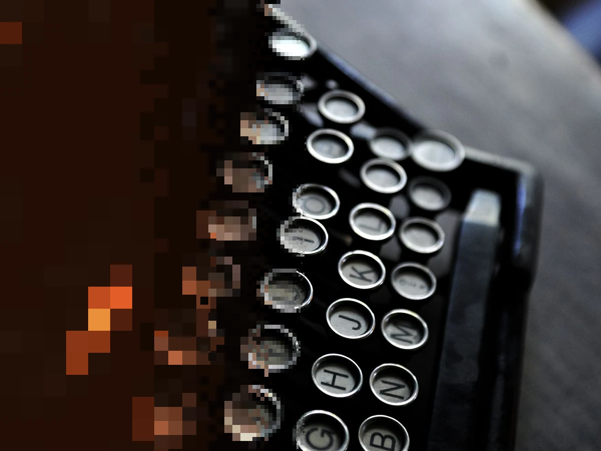 Close up of round black typewriter keys with white Latin letters, the left side breaking into pixels